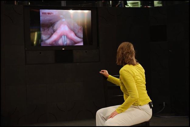 Szenenbild der Oper 'Sotto Voce' aufgenommen 2011 im Berliner Hauptbahnhof: Die Sängerin singt ein Duo mit ihren an die Wand projizierten Stimmbändern